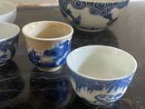 four blue and white bowls sitting on top of a black table