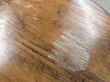 a close up of a wooden table with a brown stain on it