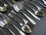 a lot of silver spoons and forks on the table
