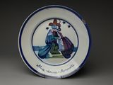 une assiette bleue et blanche sur laquelle figure l'image d'un homme tenant un sac