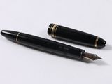 pair of black and gold fountain pens sitting on top of a white surface