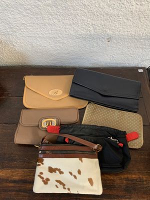 Plusieurs sacs à main différents sont alignés sur une table en bois