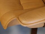 a close up of a chair with a brown leather seat