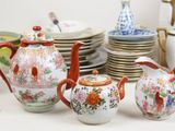 many different types of teapots and saucers on the table