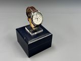 an image of a watch sitting on top of a wooden stand