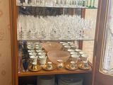 a wooden cabinet with many plates and glasses on it