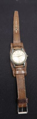 montre-bracelet avec bracelet en cuir marron sur fond noir