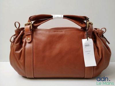 Le grand sac à main marron est posé sur une table.