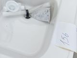 a white sink with a toothbrush and a toothpaste in it