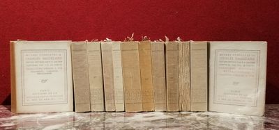 plusieurs livres posés sur une table en marbre, près d'un mur rouge