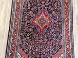 rug on the floor in a room with wooden flooring and white walls
