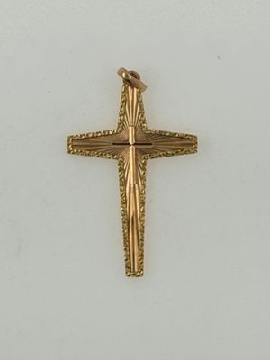 a close up of a gold cross on a white surface