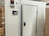 une photo d'un congélateur dans un entrepôt, avec des cartons
