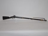 an old rifle on a white table with a black handle