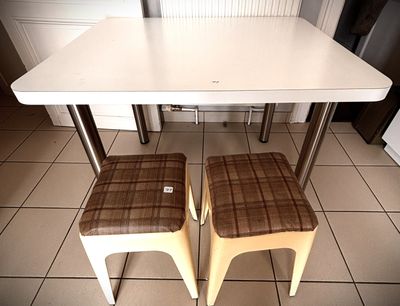 two stools sitting next to a table in a kitchen