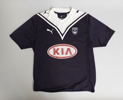 a close up of a black and white shirt with an oval logo on it