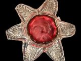 a glass flower with a red center on a black background