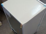 an image of a white refrigerator in a warehouse