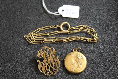 un gros plan sur un collier en or et deux breloques posés sur une surface noire