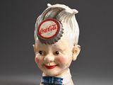 a small statue of a boy with a hat on it ' s head