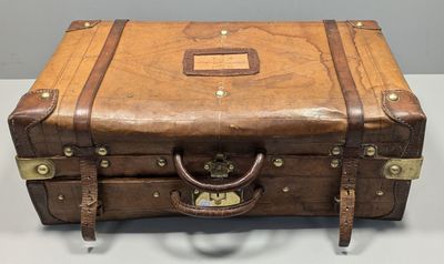 une valise marron posée sur une table blanche