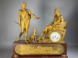 a gold statue of a man and a woman sitting on a bench with a dog
