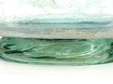 a glass bowl with a green base on a white surface