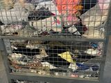 a metal cart with a bunch of clothes inside of it