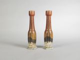 pair of vases on a white background with trees in the background