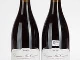 deux bouteilles de vin rouge posées l'une à côté de l'autre sur une surface blanche