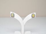 a pair of oplite and diamond earrings on a white stand