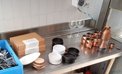 a metal counter with a bunch of utensils on it