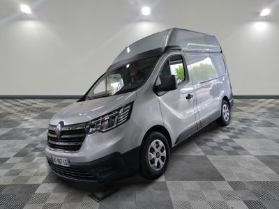 La camionnette argentée est garée sur un sol en carrelage à damier.