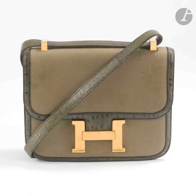 Le sac à main marron et noir est posé sur une surface blanche.