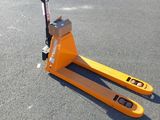 un chariot élévateur jaune garé au milieu d'un parking, à côté d'un parcmètre