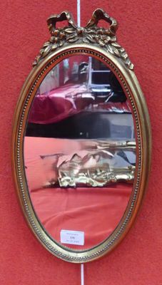 a mirror hanging on a wall with a car in the reflection