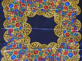 a blue and yellow scarf with colorful stones on it