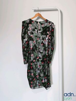 une robe suspendue à un cintre dans un coin de la pièce