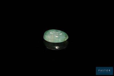 un gros plan d'une pierre de jade verte sur une surface noire