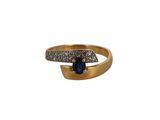 gros plan d'une bague en or avec une pierre bleue