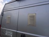 a silver van parked in a parking lot with its door open