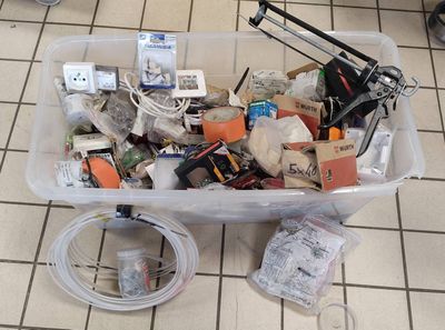 a plastic container filled with assorted items on a tiled floor