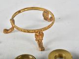 a gold ring and a gold candle holder on a white table