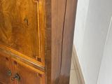 a wooden cabinet with a black top on a tiled floor