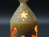 lampe en céramique ornée d'un motif représentant une étoile et un poisson sur le côté extérieur