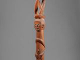 an image of a wooden sculpture of a man holding a cane