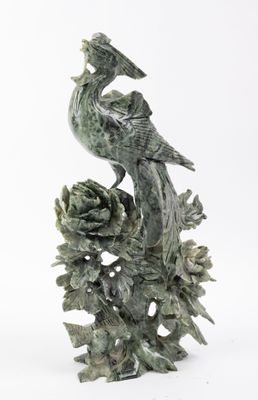 une statue représentant un oiseau perché sur une branche d'arbre
