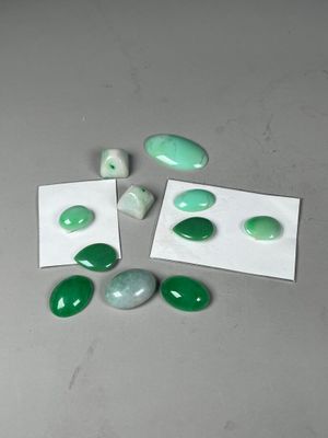 several green and white stones on a table with white paper