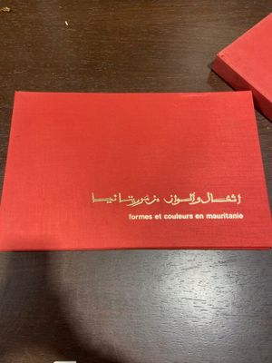 deux cartons rouges portant des inscriptions en arabe, posés sur une table