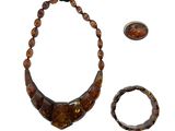 collier, bracelet et bague ornés d'une image représentant le visage d'une femme sur fond blanc